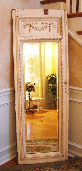 Una puerta de madera convertida en marco de espejo.