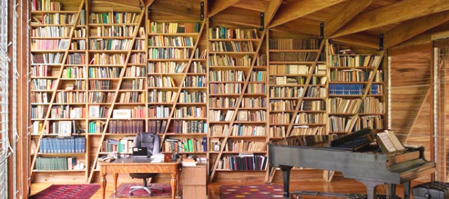 Una biblioteca con un estante para libros y un sofá con un librero